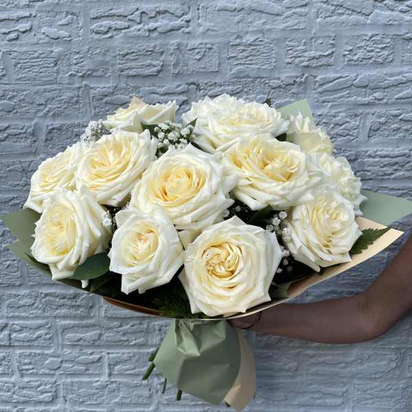 Bouquet of white roses wrapped in pale green paper