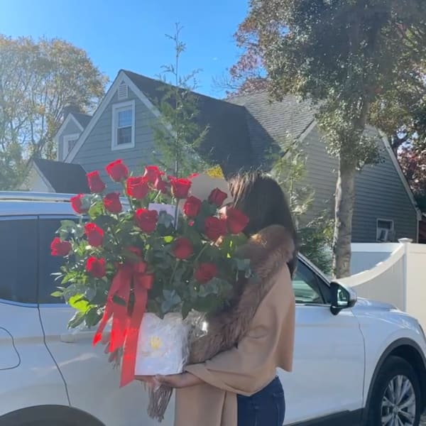 Large bouquet of red roses wrapped with a red ribbon