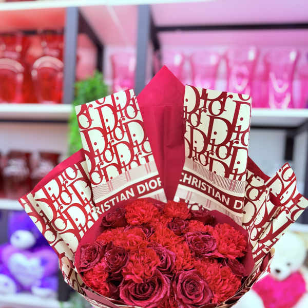 Bouquet of red roses and carnations wrapped in patterned paper