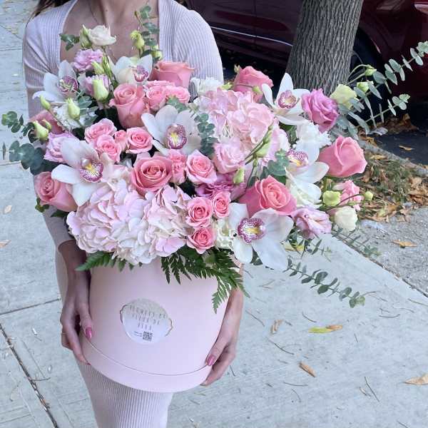 Pink roses and white orchids in a round pink box