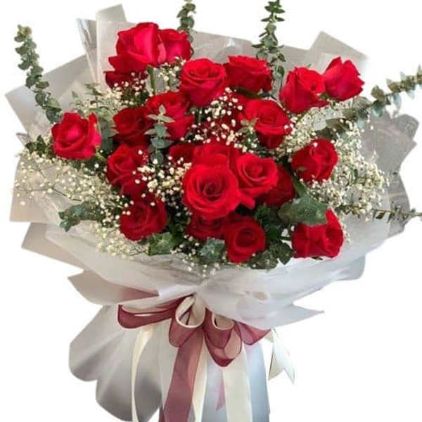 Bouquet of red roses wrapped in white paper with a ribbon