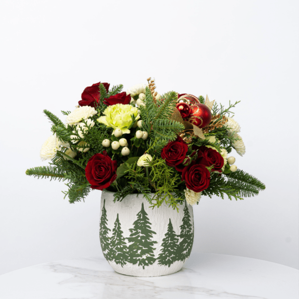 Red roses and white flowers in a holiday vase with ornaments