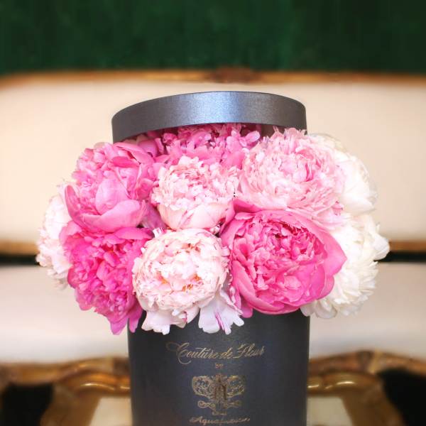 Pink peonies arranged in a black hat box