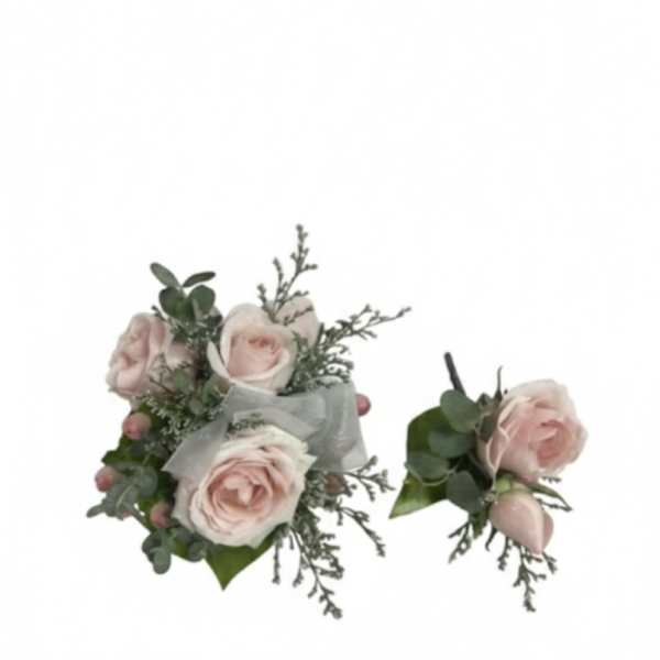 Two pale pink rose boutonnieres with greenery and ribbon