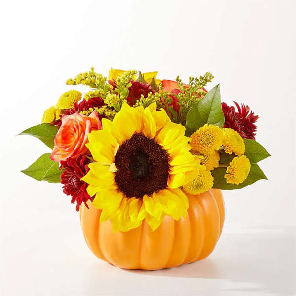 Sunflower and mixed autumn bouquet in an orange pumpkin container