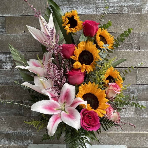 Pink roses and lilies with sunflowers in a white vase