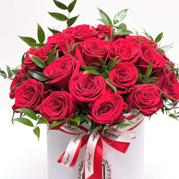 Bouquet of red roses in a white hatbox with a red ribbon