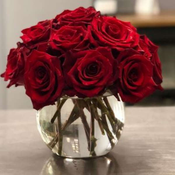 Red roses arranged in a clear glass vase