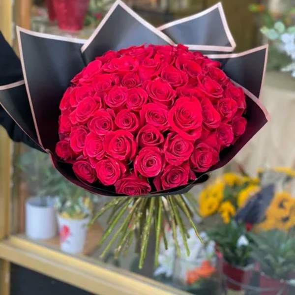 Bouquet of red roses wrapped in black paper