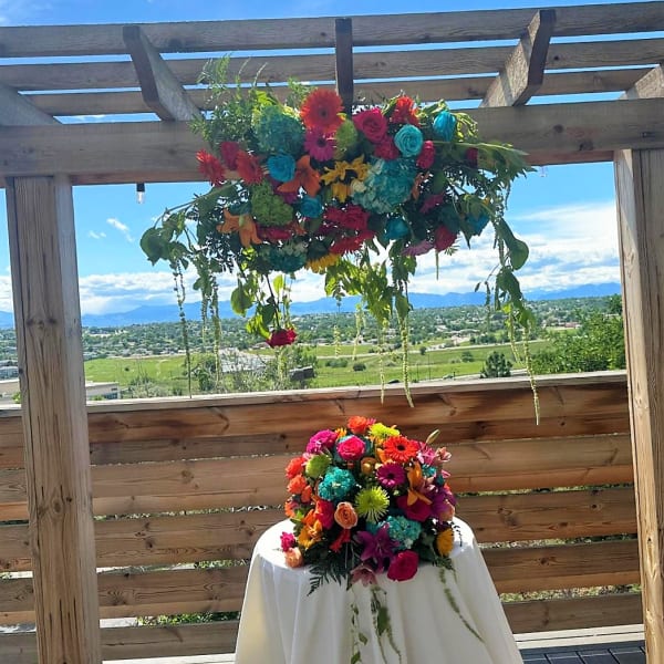 Bright multicolored floral arrangements on a table and hanging overhead