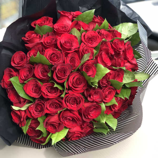 Bouquet of red roses wrapped in black paper
