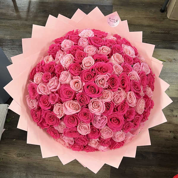 Large bouquet of pink and hot pink roses wrapped in pale pink paper