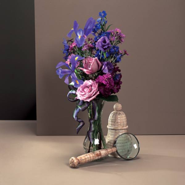 Bouquet of purple and pink flowers in a glass vase with a ribbon