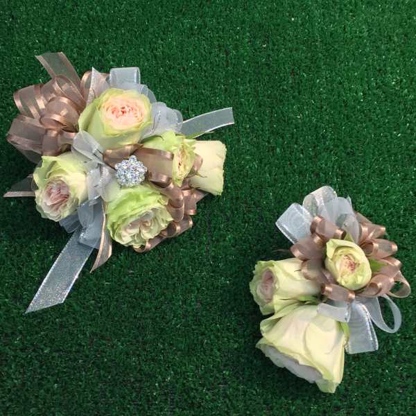 Two small rose bouquets with ribbon bows on green turf