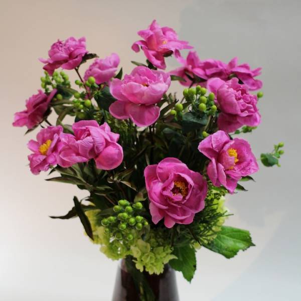 Pink flowers arranged in a dark glass vase
