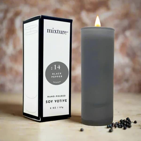 Gray soy votive candle beside its box with peppercorns