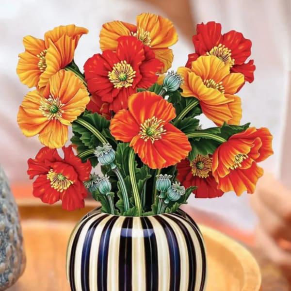 Orange and red poppy bouquet in a striped vase