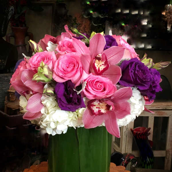 Pink and purple flower arrangement in a green vase