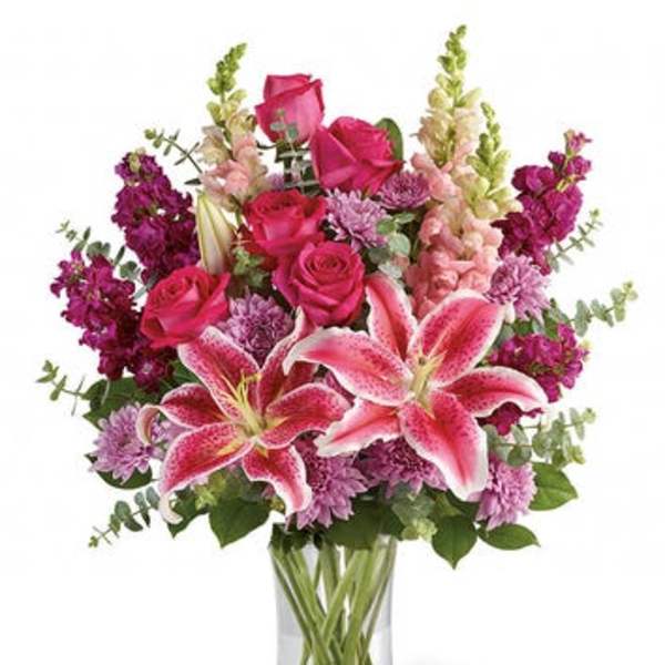 Pink lilies and roses in a clear glass vase