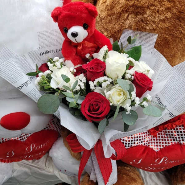 Bouquet of red and white roses with a teddy bear