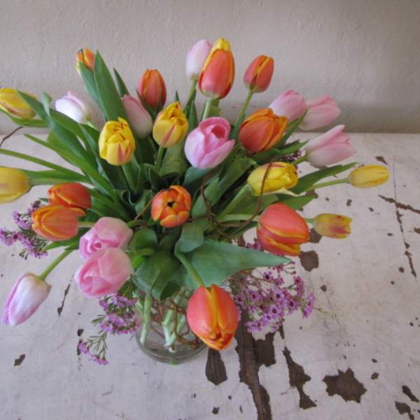 Bouquet of multicolored tulips in a clear glass vase