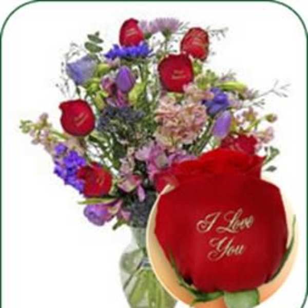 Mixed bouquet with red roses and purple flowers in a glass vase