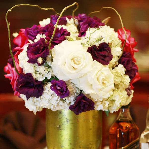 White and purple rose arrangement in a gold vase