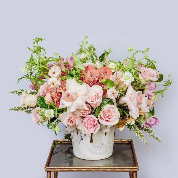 Pink and peach floral arrangement in a white vase
