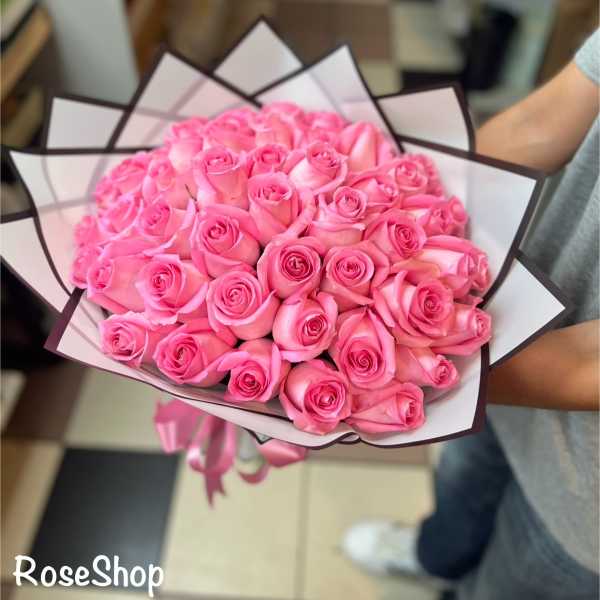 Bouquet of pink roses wrapped in white and dark-edged paper