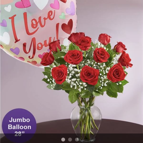 Red roses in a glass vase with a heart-shaped "I Love You" balloon