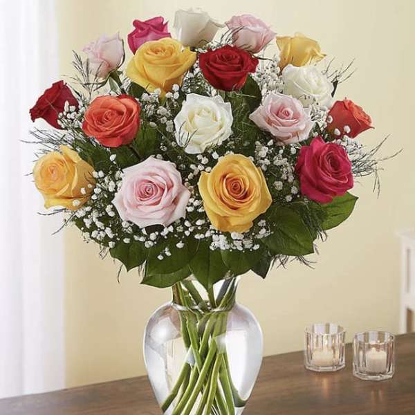 Mixed roses in a clear glass vase with baby's breath