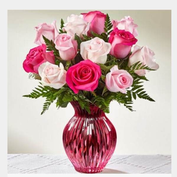 Pink and white roses in a red glass vase