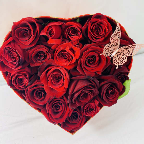 Heart-shaped box of red roses with a butterfly decoration