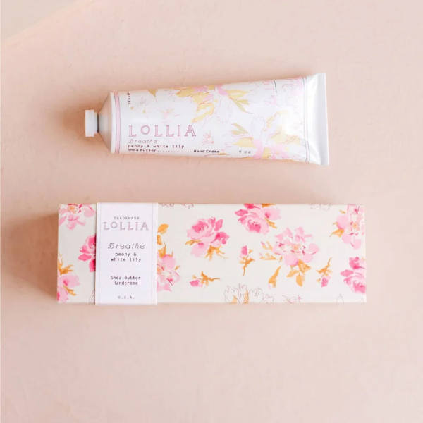 Hand cream tube and floral box on a pale pink background