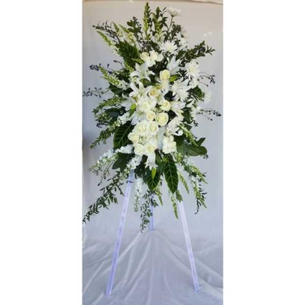 Tall white floral standing spray on a tripod easel