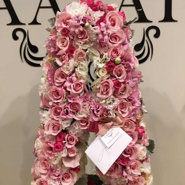 Pink rose and hydrangea floral arrangement shaped like a large letter A
