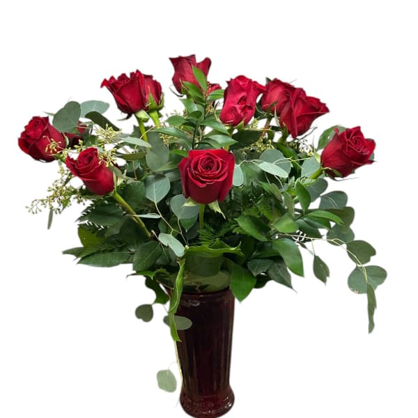 Red roses arranged in a tall dark vase with greenery