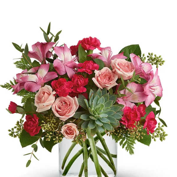 Pink roses and carnations in a clear glass vase with a succulent center