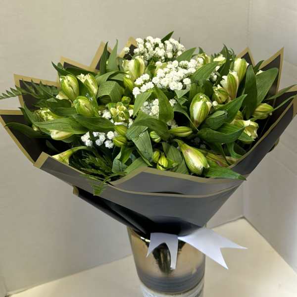 Bouquet of green buds and white filler flowers in a tall vase