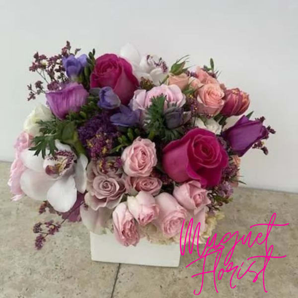 Bouquet of pink, purple, and white roses in a white box