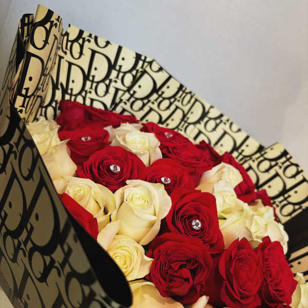 Bouquet of red and white roses wrapped in patterned paper