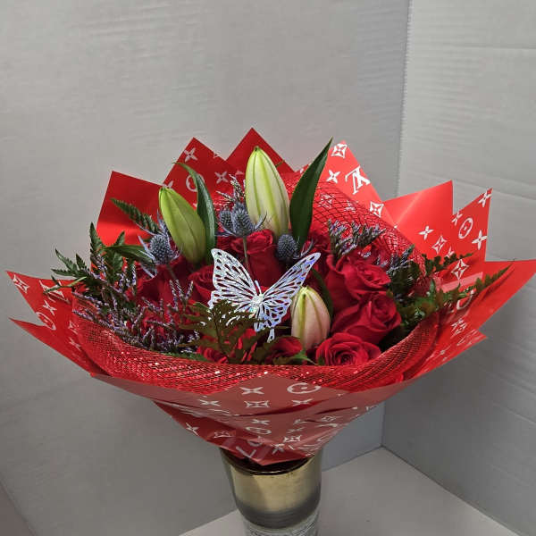Red rose bouquet with lily buds in a gold vase