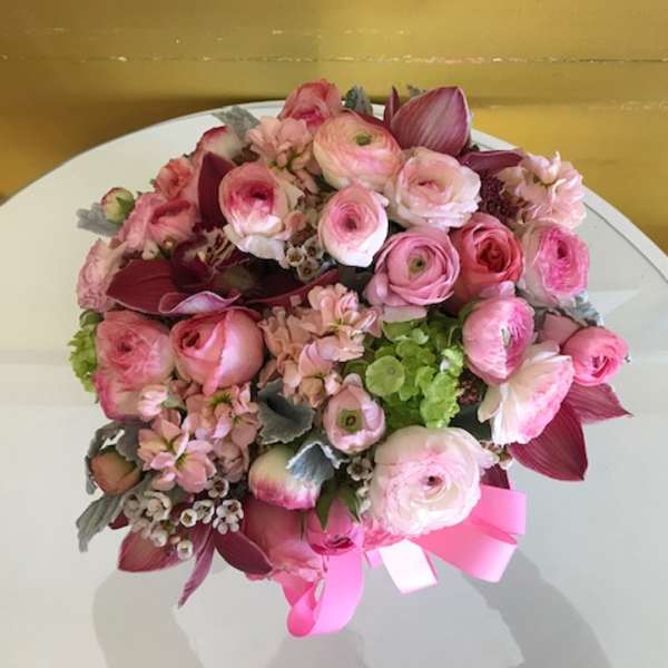 Pink and burgundy bouquet with a ribbon on a white table