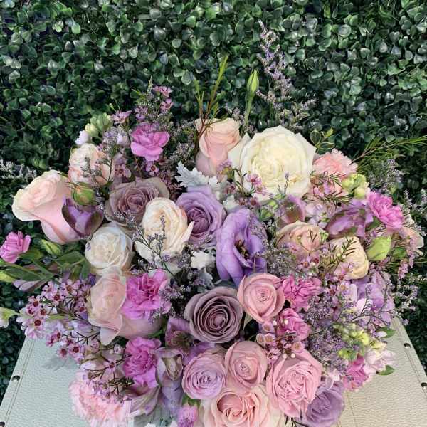 Pastel bouquet of roses and lisianthus with small purple filler flowers