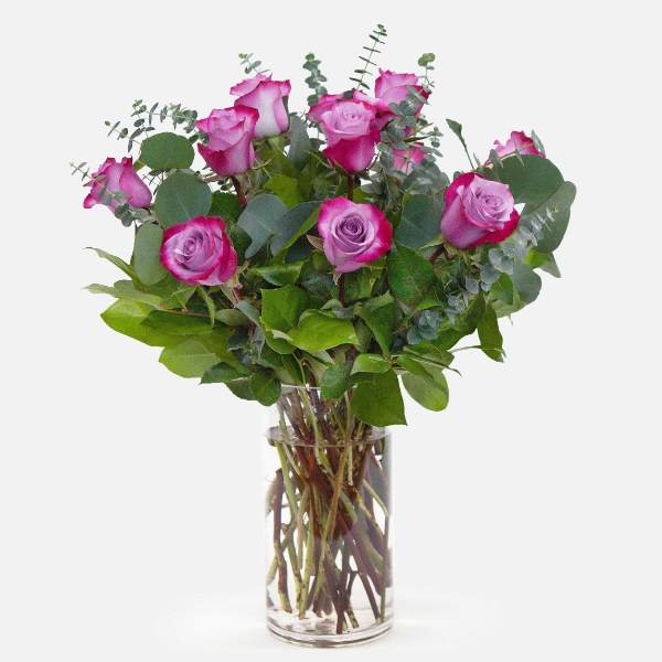 Pink roses in a clear glass vase with eucalyptus