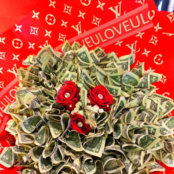 Bouquet of folded dollar bills with red roses on a red patterned background
