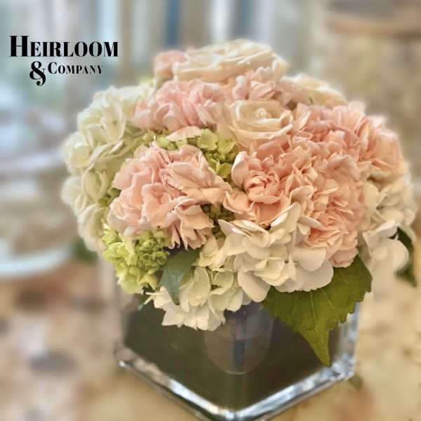Blush and white floral arrangement in a square glass vase