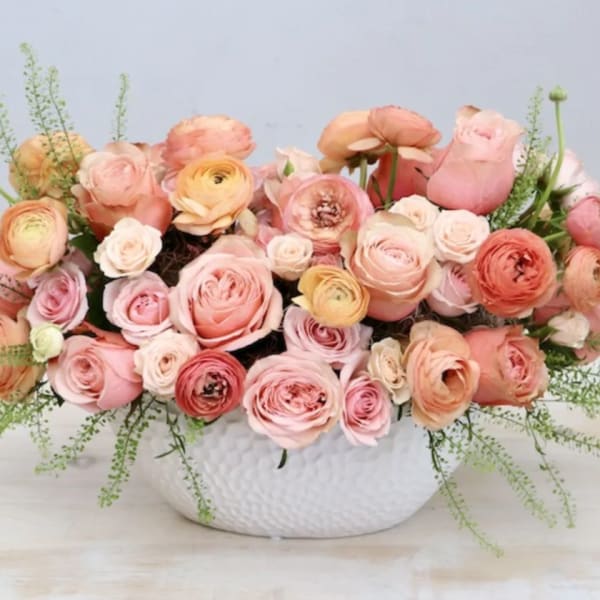 Pink and peach ranunculus bouquet in a white textured vase