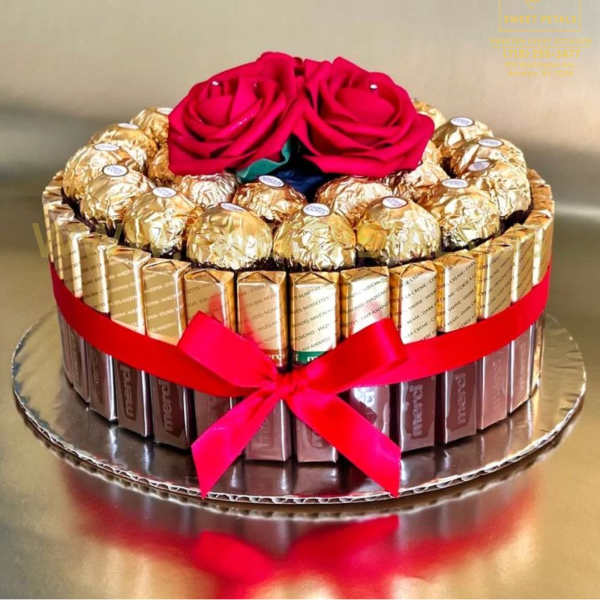 Chocolate gift box topped with two red roses and a ribbon