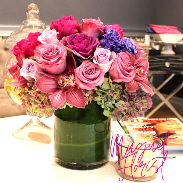 Pink and purple floral arrangement in a glass vase